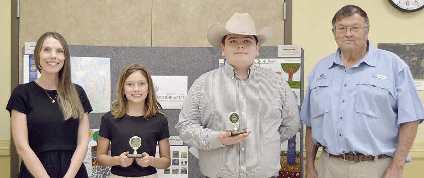 ESSAY CONTEST winners in the age 13 and under division were Bailey Brown (second from left) of Round Top-Carmine ISD and Rilan Karisch (second from right), home-schooled. Award sponsors were Prosperity Bank, represented by Ashley Firkins (left), and Carmine State Bank, represented by Roy Wied (right).