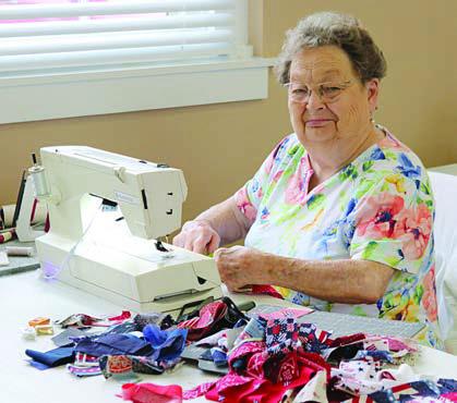 At the sewing mach ine with a quilt block is Kathy Bertsch.