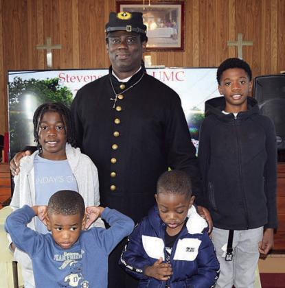 Fom left: King Burley, age 10; Samir Burley, 3; speaker Chaplain Coy Poitier; Damoni Peterson, 4; and Dominic Peterson, 13. The youth are Willie Matthews’ nephews.
