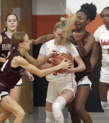 Jenna Guentert battles two Brahmarettes for a loose ball in the first half last Thursday. Sticker Photo By Darrell Vyvjala