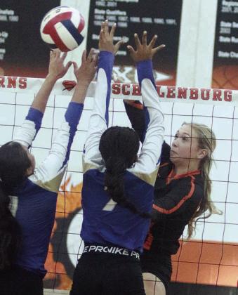Reagan Dusek sends a spike past two Lady Hornets to score in the first set. Sticker Photo By Darrell Vyvjala