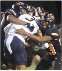 Jayvan Luhrs (left) and Ja’kele Houston stack up Gabriel Silansky for no gain in the first quarter. Sticker Photo By Darrell Vyvjala