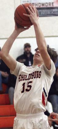 William Eudy scores at the basket in the first quarter last Tuesday. Sticker Photo By Darrell Vyvjala Left: