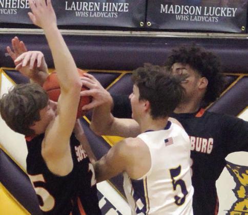 Jayvan Luhrs (right) dislodges the ball from a Wildcat to force a turnover in the fourth quarter with help from Zane Brenek. Sticker Photo By Darrell Vyvjala