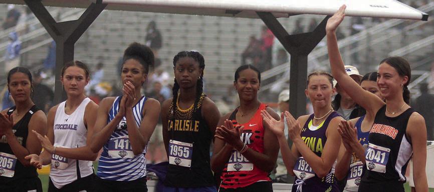 Meredith Magliolo waves to the fans in the stands at Mike A. Myers Stadium prior to the high jump competition last Friday. With the best qualifying height, she was the last of nine qualifiers to be introduced. Sticker Photo By Darrell Vyvjala
