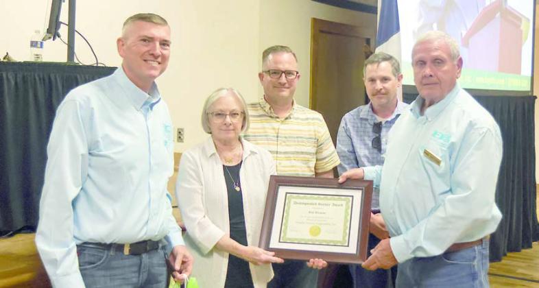 Bill Brisco e, a 19-year director who died in February, was remembered by the board. FEC representatives and Briscoe family members shown with a distinguished service award given in his honor and a token of appreciation from the cooperative are (from left) FEC General Manager/CEO Doug Lambert; Mrs. Patricia Briscoe and her sons Corey Briscoe and Tyson Briscoe; and FEC board president Joseph Kruppa.