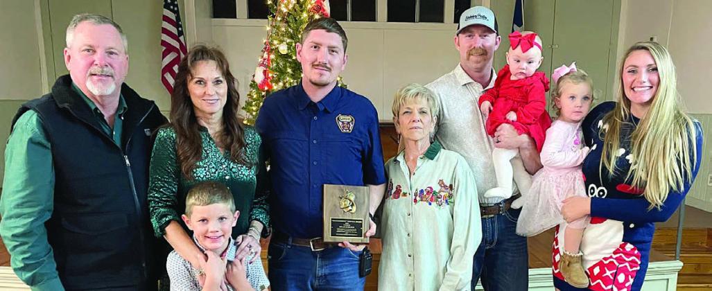 The SVFD OUTSTANDING SERVICE AWARD for 2025 went to Dylan Schilhab (center, holding plaque). He made the highest percentage of calls, meetings and drills at 89 percent. The award is sponsored annually by the family of the late Chief Roland Proske and his wife Pat Proske. Making the presentation were (from left) Jeff and Terry Proske, Will Proske, (continuing aftter Schilhab) Pat Proske, Doran Proske holding Clara, and Kelsey Proske holding Lace. . Sticker Photo By Darrell Vyvjala