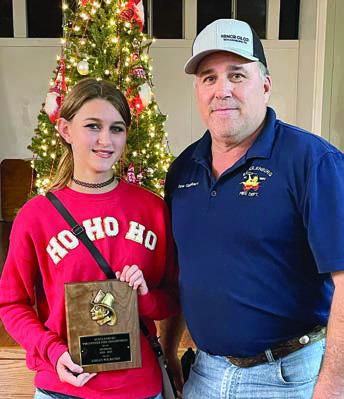 SPONSOR FOR 2024-25 receiving a plaque at the Christmas party was Logan Wilbanks (left), shown with Fire Chief Darren Guentert. Not present were 2024-25 mascot William Eudy, 2025-26 sponsor Elly Wotipka and 2025-26 mascot Kaleb Zapalac. Sticker Photo By Darrell Vyvjala