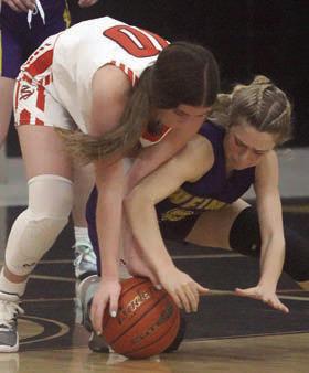 Gracie Burton contends with a Ladycat to get a loose ball in the third quarter. Sticker Photo By Darrell Vyvjala