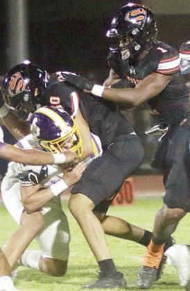 Jayden Olmos clears the way for DaTerrion Houston in the first quarter. Sticker Photo By Layne Vyvjala