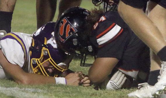 Keigan Johnson secures a fumble recovery in the third quarter. Sticker Photo By Darrell Vyvjala
