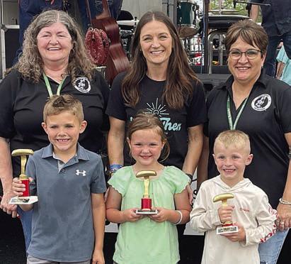 SAUSAGE TOSS - 5-8 DIVISION: Front, from left: Hollis Brower, first place; Ellie Klesel, second place; and Bryson Dees, third place. Back, from left: Sausagefest Committee member Debbie Preece, Erin Wotipka of “And Then,” and Sausagefest Committee member Liz Garcia Vaughan. Sticker Photo By Darrell Vyvjala