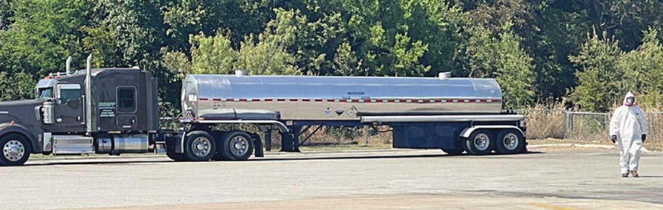 A member of the hazmat team returns from looking over the tanker that had a valve leaking sulphur dioxide. The rig was moved to the far northeast side of the parking lot behind Pilot. Photo Courtesy of the Fayette County Office of Emergency Management