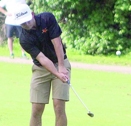 Jackson Faith lofts a chip shot onto the green of the par-5 No. 14 hole in Monday’s round. Sticker Photo By Darrell Vyvjala
