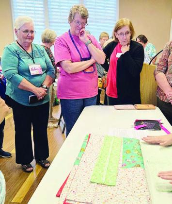 Photo at right – Watching a demonstration by Anita Todd (hands only) are Helen Muras, Debbie Huebel and Gay Dobbs.