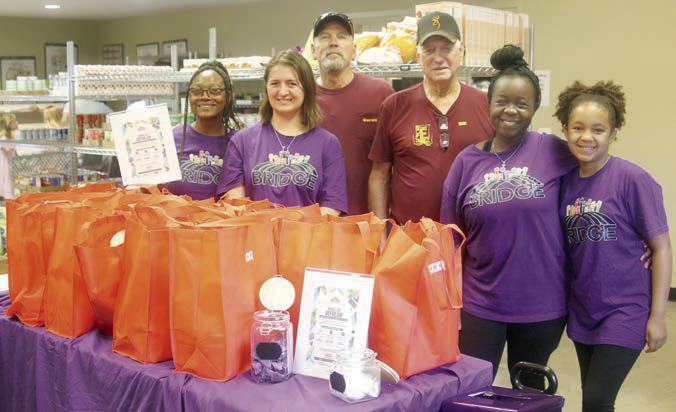 Shown at the Schulenburg Area Food Pantry last Thursday with the tote bags containing back-to-school essentials are (from left) Shay Billings and Liberty Sirilo with BRIDGE, Food Pantry volunteers Gerald Smith and Bill Michalke, and Rebecca Powe and Peyton Powe-Byrd with BRIDGE. Sticker Photo By Darrell Vyvjala