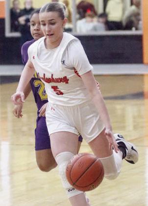 Jenna Guentert dribbles past a Ladycat defender in the fourth quarter. Sticker Photo By Darrell Vyvjala