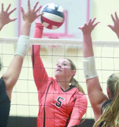 Haylee Vacek sends a kill past two Cypress Christian blockers. Sticker Photo By Darrell Vyvjala