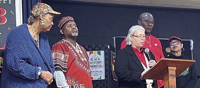 Mayor Connie Koopmann (at the podium) reads the proclamation presented at the City Council meeting last week in honor of Black History Month and the local celebration. Looking on are (from left) event organizers Marsha Caine and Robert Moore along with (from right) event master of ceremonies Dr. Virginia Glass Berry and City Council Alderman Greg Thomas. Sticker Photo By Darrell Vyvjala