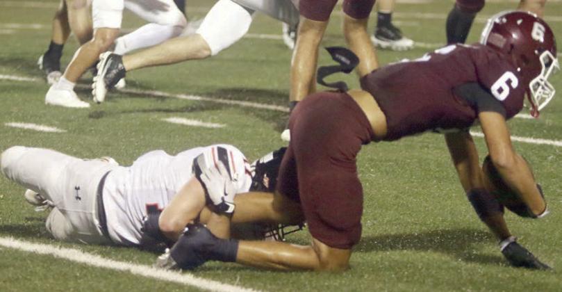 Caden Herzik brings Sutton Haynes down after a 2-yard gain in the first quarter. Sticker Photo By Darrell Vyvjala