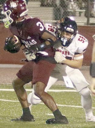 Preston Kahn wraps up Lamere Barnett for no gain on a first-quarter carry. Sticker Photo By Darrell Vyvjala