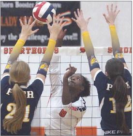 Jessalyn Gipson bangs a kill off Pirette blockers in the third set. Sticker Photo By Darrell Vyvjala