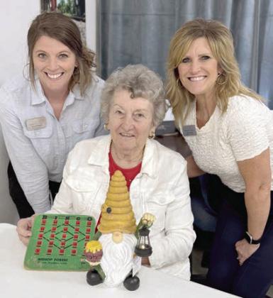As th eir blac kout pr ize for bingo, Chyla Podhajsky (left) and JoAnn Shimek (right) from Wellsential brought the cutest gnome solar light. Helen Janda (center) was the lucky winner.