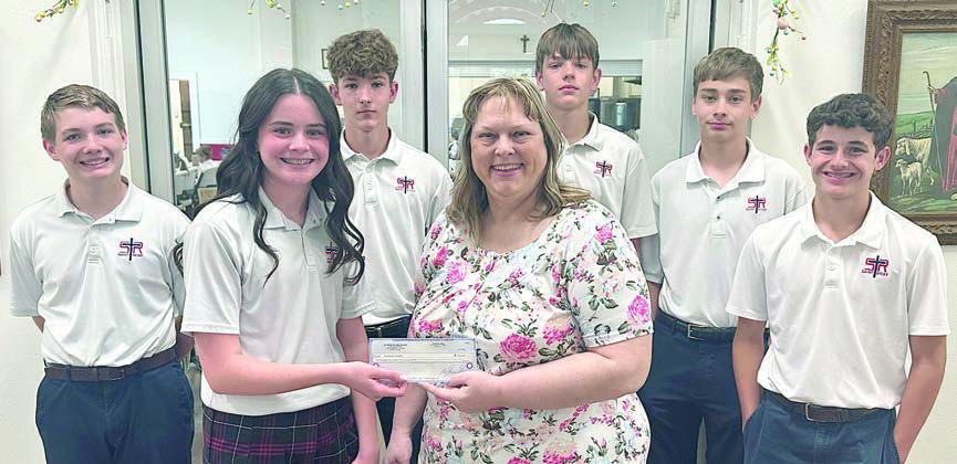 St. Rose of Lima Catholic School students raised money to donate to the Schulenburg Area Food Pantry. Charlotte Schmidt (front left), SRS eighth grader, represented the school in presenting the check to Sheila Brossmann (front right), who accepted on behalf of the Food Pantry. Other students shown are (back row, from left) Patrick Taylor, Austin Reeves, Jacob Schramek, Justin Schramek and Cal Schiffli.