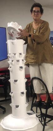 A Tower Garden growing system is being assembled by Stephanie Shroyer.