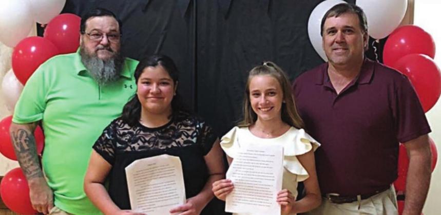 6TH GRADE • 1ST & 2ND PLACE WINNERS – Second place winner Destani Brown (second from left) of St. Rose of Lima Catholic School with her father, David Brown (left); and first place winner Jenna Guentert (second from right) of St. Rose of Lima Catholic School with her father, Darren Guentert (right).