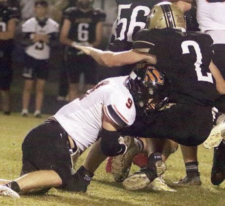 Emerson Harvey drops Chris Warren for a loss in the fourth quarter. Sticker Photo By Darrell Vyvjala