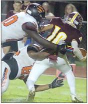 Tavondrick Ellison (top) and Jayvan Luhrs pressure quarterback Gunner Ferguson on a thirddown pass in the fourth quarter. Sticker Photo By Darrell Vyvjala
