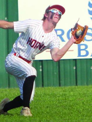 Left fielder Zane Brenek secures a fly ball against Sacred Heart. Sticker Photo By Darrell Vyvjala
