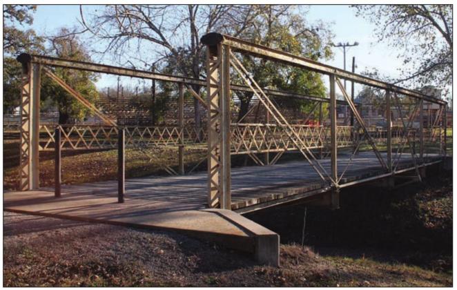 The pedestrian bridge in Wolters Park that leads to and from the Rodeo Arena was one of two such structures considered for rehab work by the City Council at Monday’s meeting. Sticker Photo By Darrell Vyvjala