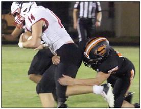 Owen Brenek brings down Colby Beck on a third-down run in the third quarter. Sticker Photo By Layne Vyvjala