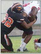 Jayvan Luhrs wrestles down Tyrone Gilmon after a short gain in the first quarter. Sticker Photo By Layne Vyvjala