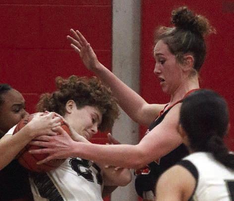 Grace Schramek ties up a Lady Panther to force a turnover. Sticker Photo By Darrell Vyvjala