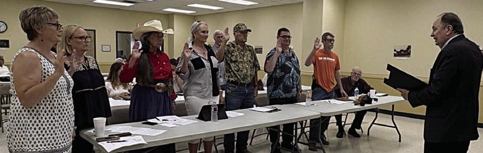 RE-ELECTED EXECUTIVE COMMITTEE MEMBERS SWORN IN – County Judge Dan Mueller (right) swore in re-elected executive committee members (standing, from left) Cindy Wingo, Kimberly Rutledge, Kathryn Geesaman, Nancy Applebe, David Barr (in back), Steven Harker, Joe Jameson and William Bernsen.