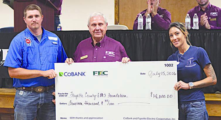 Fayette County EMS Foundatio n received $14,000 for the installation of drinking water stations at EMS agency locations. Shown are (foreground, from left) Shelby VFD assistant chief Blake Moehlmann; FEC board president Joseph Kruppa; and Fayette County EMS Foundation president Taylor Laslie.