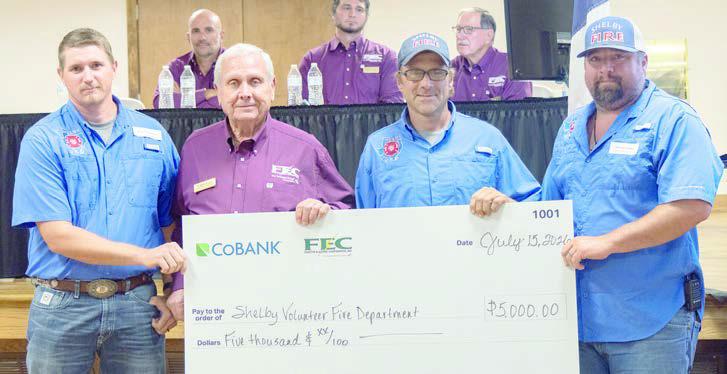 Shelby Volunteer Fire Depart ment received $5,000 to assist with the purchase of a new pumper truck. Shown are (foreground, from left) Shelby VFD assistant chief Blake Moehlmann; FEC board president Joseph Kruppa; Shelby VFD firefighter Charles Atkins; and Shelby VFD firefighter Dennis Gaskins.