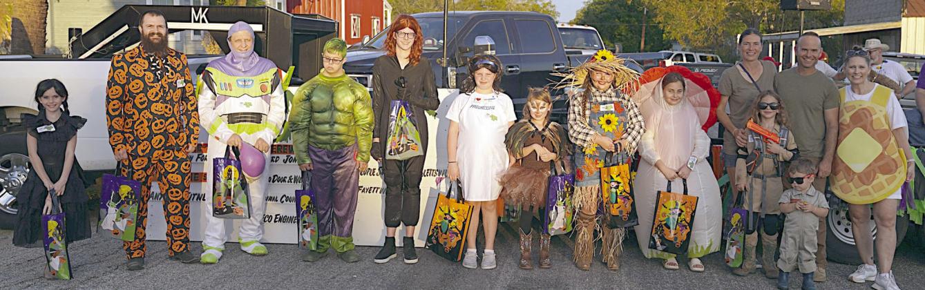 HALLOWEEN Costume contest winners at the Monster Dash were (from left) Ainsley Kutac, Garrett Novak, Rodney Kalich, Wilhelm Keilbach, Emma Kubala, Olivia Hammack, Lillie Posas, Loryn Toro, Ella Ring and Barnett family. Also shown is (right) DeeAnn Hooper, Turtle Wing founder and president.