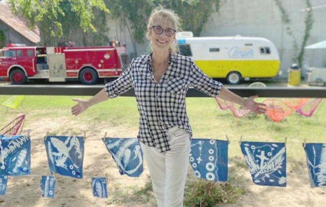 WORKSHOP LEADER – Debbie Pargac, who taught And Then members how to create cyanotypes, stands in front of the artwork they made as part of the workshop.