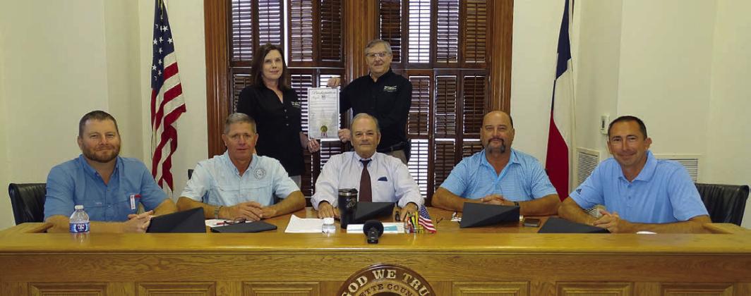 On hand for the proclamation commemorating FEC’s 85th anniversary were: (front, from left) Precinct 4 Commissioner Drew Brossmann, Precinct 3 Commissioner Harvey Berckenhoff, County Judge Joe Weber, Precinct 2 Commissioner Luke Sternadel, Precinct 1 Commissioner Jason McBroom; (back, from left) FEC Marketing and Training Coordinator Tracy Denton, and FEC General Manager Gary Don Nietsche. Photo By Melanie Berger / Courtesy of Flatonia Argus
