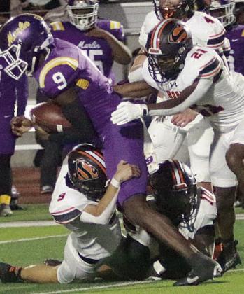 Adin Beyer (No. 9), Tavondrick Ellison (No. 10), and Demarrion Glass (No. 21) stop Roderick Suiters after a 1-yard gain in the second quarter. Sticker Photo By Layne Vyvjala