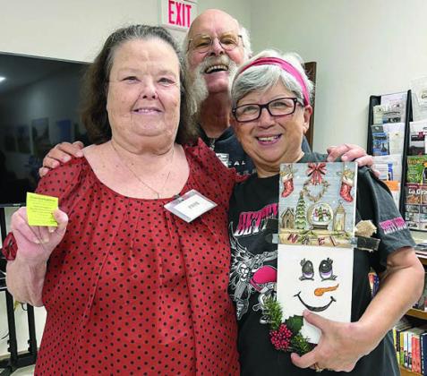 BLACKOUT Winners – Faye Smith (left) and Olga Alvarado (right) were both blackout winners so a tie-breaker was held. The grand prize was two items, a drive-thru plate and a wooden project. Alvarado won the tie-breaker but when she realized she would not be available for the drive-thru, she gave the ticket to Smith. Smith is shown holding her ticket, and Alvarado holds the seasonal prize. Also shown is Rusti Beckmann (center)