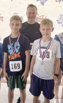 Farthest traveled – Kevin Muenster with sons Nate (left) and Grant from Dallas. Sticker Photo By Darrell Vyvjala