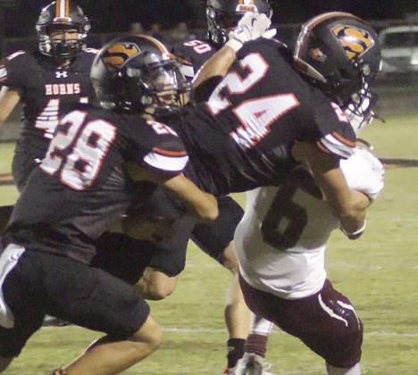 Mason Kunschick (No. 24) pulls down David Fraga on a kickoff return with help from Cody Hall. Sticker Photo By Layne Vyvjala
