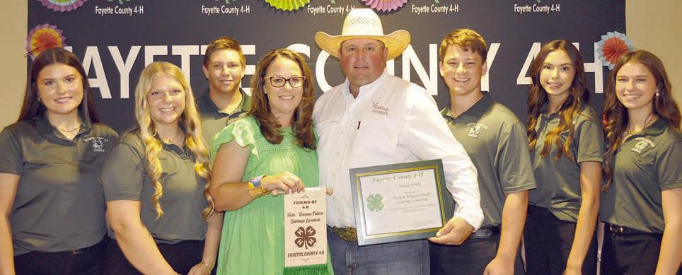 Friend of 4-H – Giddings Livestock Commission, represented by Raegan and Todd Fritsch (front center, holding certificate and  banner), with 2023-24 County 4-H Council officers (back row, from left) Madeline Willrich, Kaylee Hensley, Railey Nieto, Cooper Mau, Tori Newton and Harper Mau.