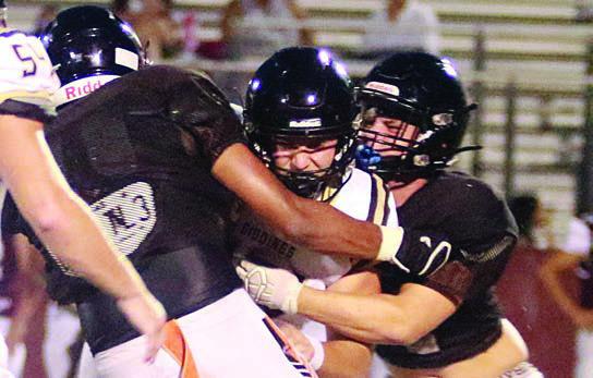 Jayvan Luhrs (left) and Preston Kahn team up for a sack of the Giddings quarterback. Sticker Photo By Darrell Vyvjala