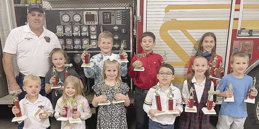 SRS WINNERS - front, from left: Allie Neiser (1st pre-K), Luke Hudec (2nd pre-K), Harrison Novick (1st kinder), Paisley Guentert (2nd kinder), Ryker Demel (1st-1st grade), Myles Krenek (2nd-1st grade), Ree Lichnovsky (1st-2nd grade), and Hagan Holub (2nd-2nd grade); Back, from left: Fire Chief Guentert, Micah Garcia (1st-3rd grade), Adam Reeves (2nd-3rd  grade), Adelyn Hollas (1st-4th grade),  Brody Brossmann (2nd-4th grade), and Brielle Goedrich (1st-5th grade).  Not shown: Noah Heger (2nd-5th grade).